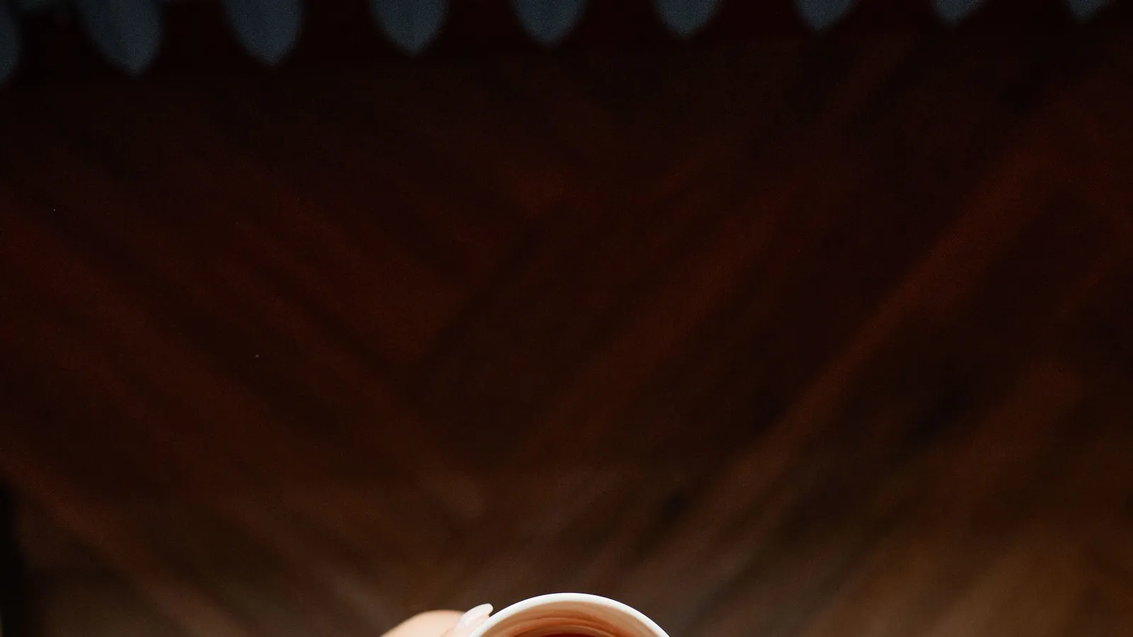 Hands hold a warm cup of tea during a quiet pause.